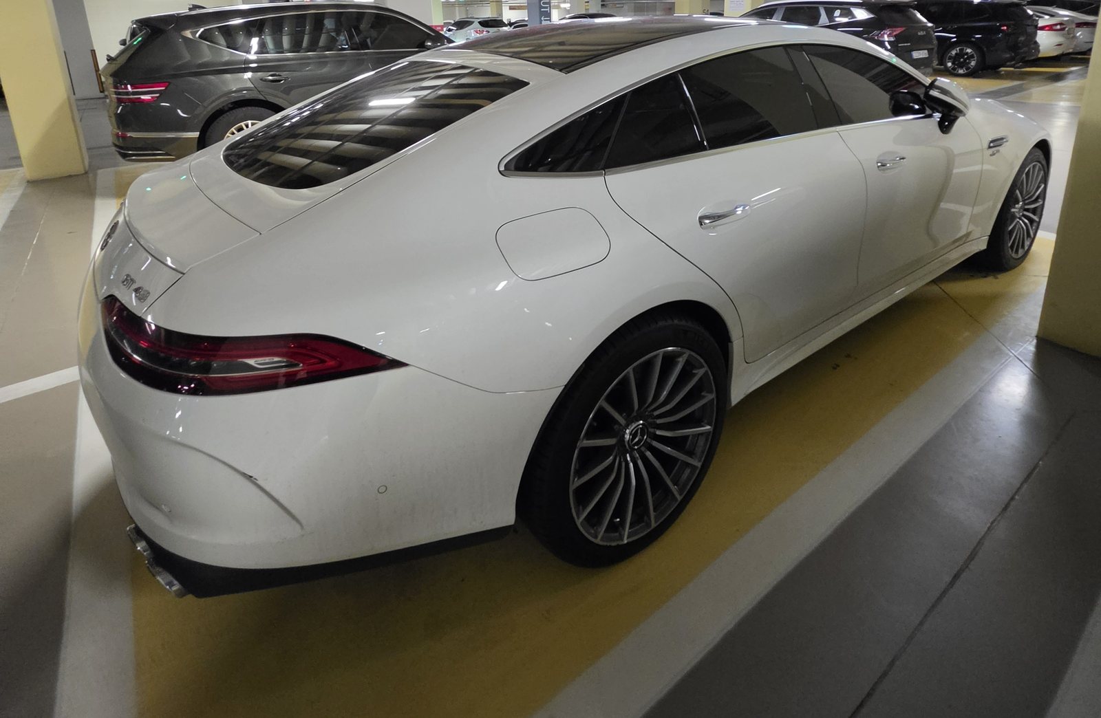 AMG GT43 우측 후면 3/4 각도. 지붕선이 뒷바퀴 쪽으로 낮게 떨어지는 모습이 보인다.