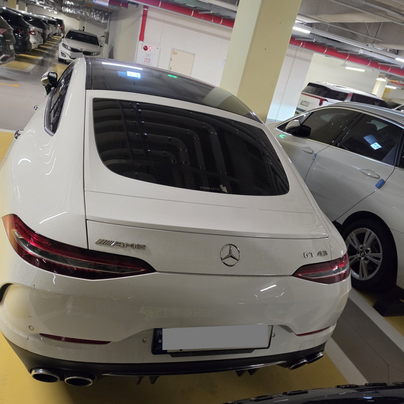 AMG GT43 정후면. AMG 레터링과 GT 43 뱃지, 네 개의 원형 배기구가 보인다. 번호판은 가렸다.
