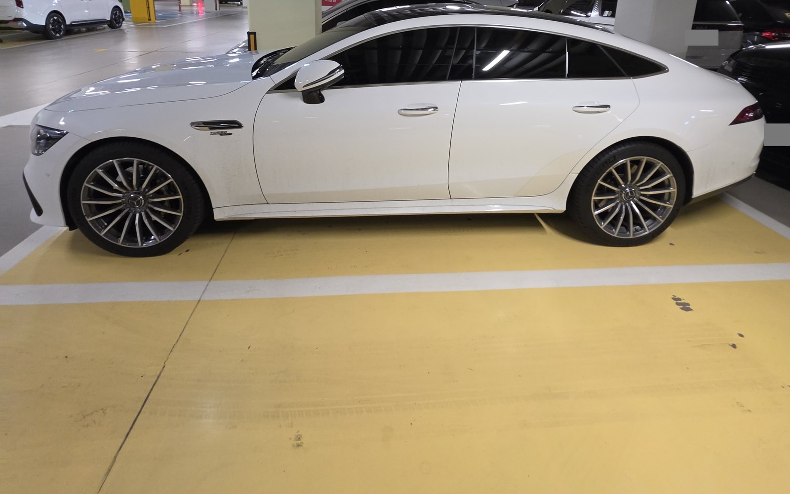 메르세데스-AMG GT43 4도어 쿠페 측면. 흰색 차체에 지붕이 뒤로 길게 흘러내리는 패스트백 형상이다.